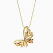 Gold butterfly pendant necklace with red stones on a white background